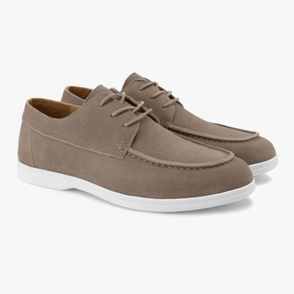 Pair of brown suede shoes with white soles on a white background