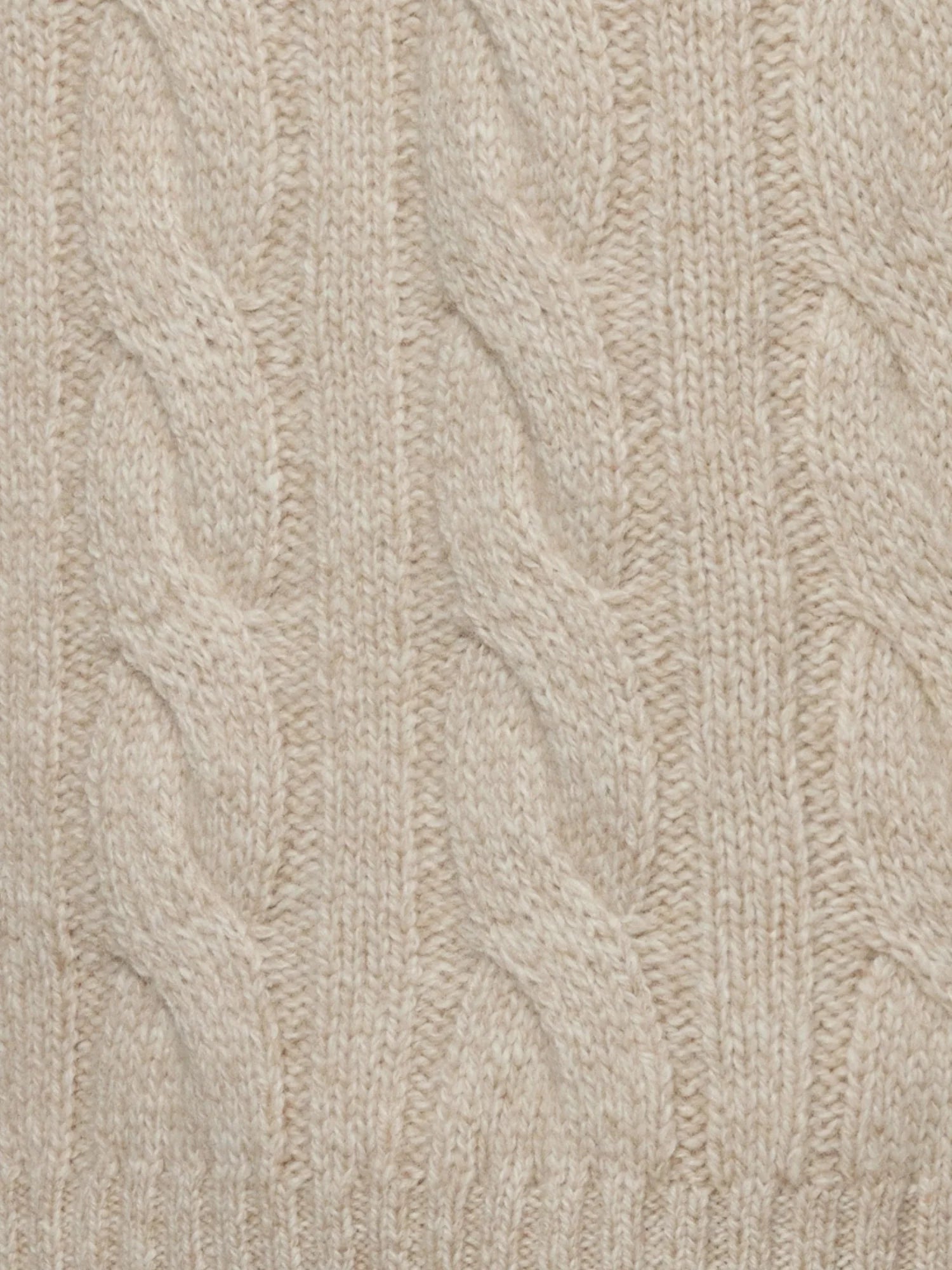 Close-up of beige knitted fabric with cable pattern