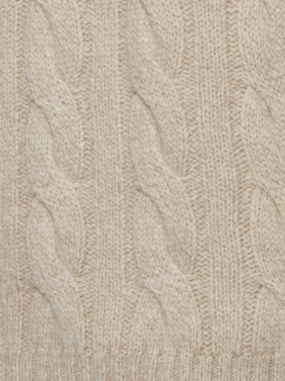 Close-up of beige knitted fabric with cable pattern