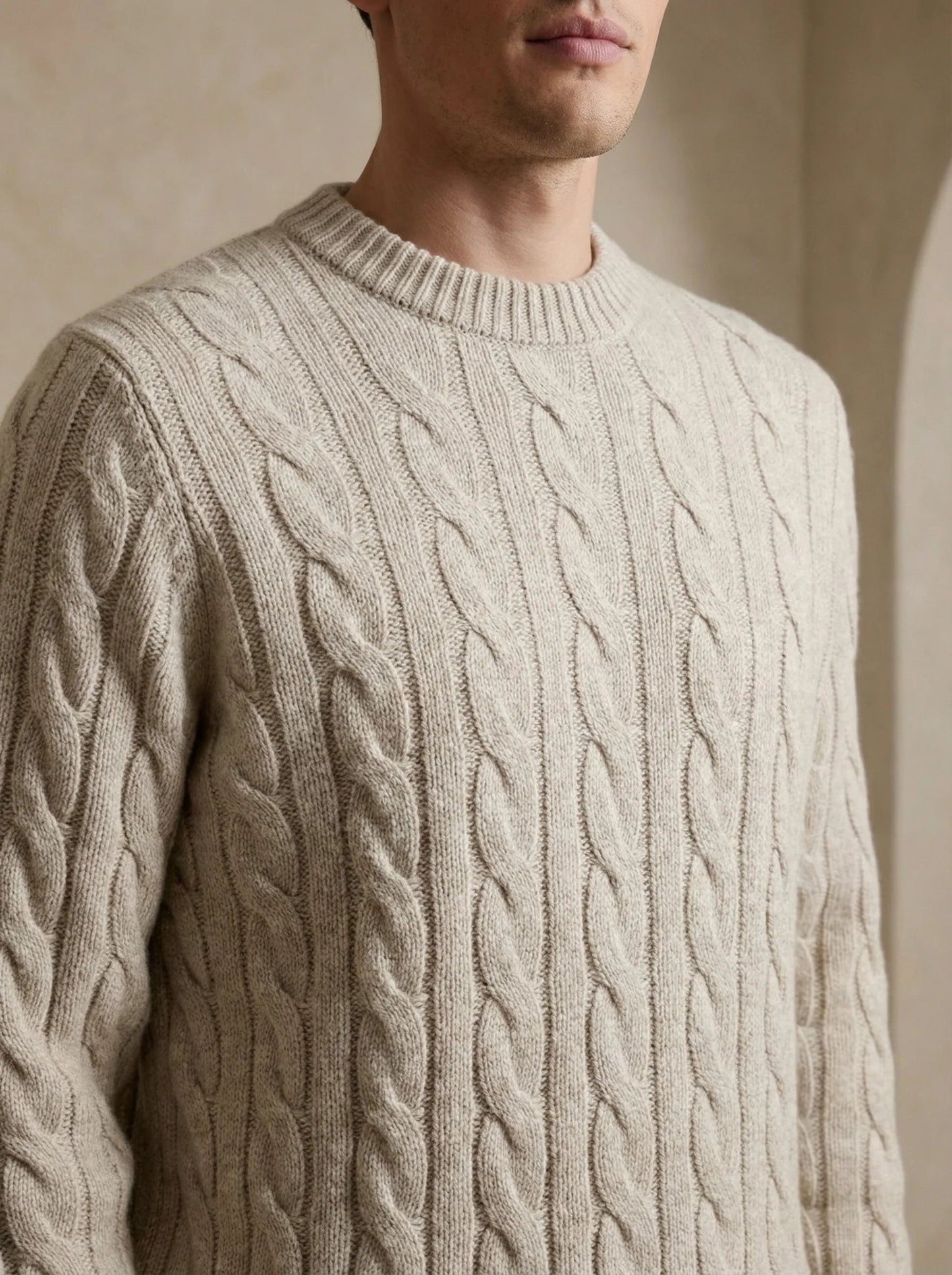 Man wearing a beige 100% cashmere sweater with a refined ribbed crewneck and cuffs.