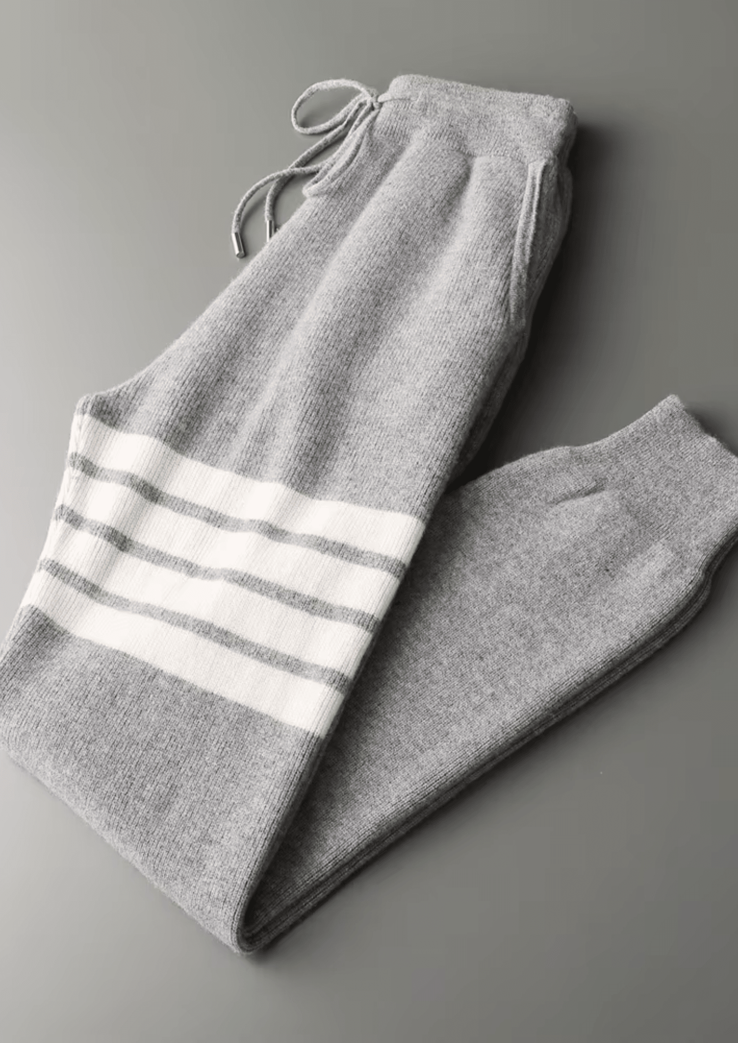 Men’s heather gray Merino wool tracksuit featuring a pullover hoodie and joggers with signature white stripes on the sleeve and thigh.