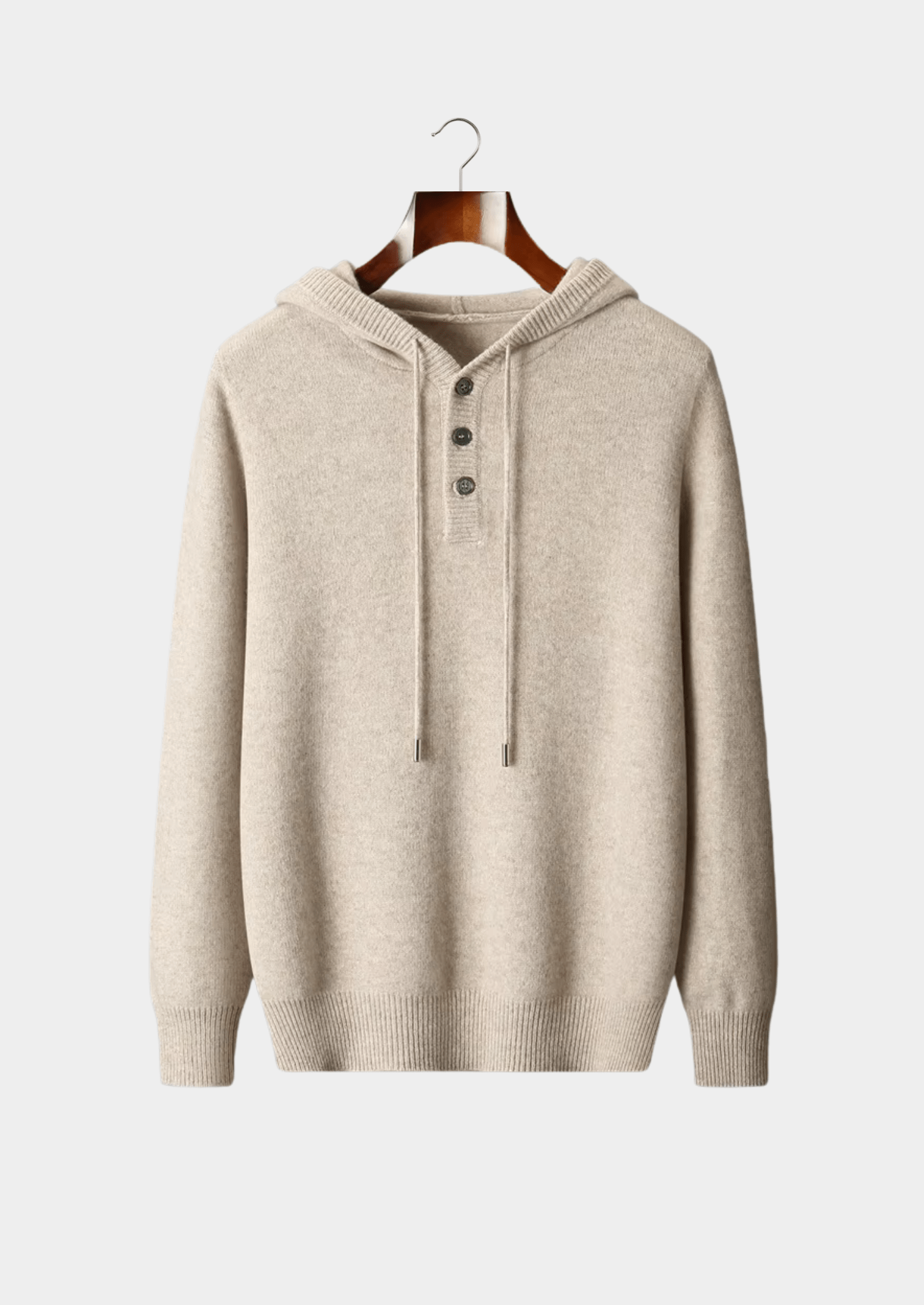 Beige hoodie on a wooden hanger against a light gray background