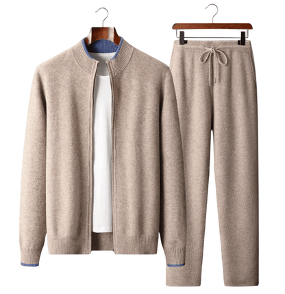 Beige sweater and pants set on hangers against a white background