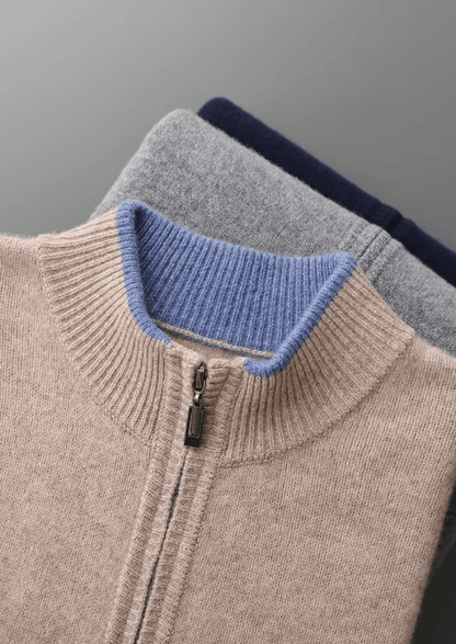 Close-up of a sweater with a blue collar and gray sleeves on a gray background