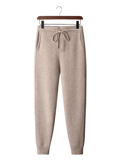 Beige sweatpants on a hanger against a white background
