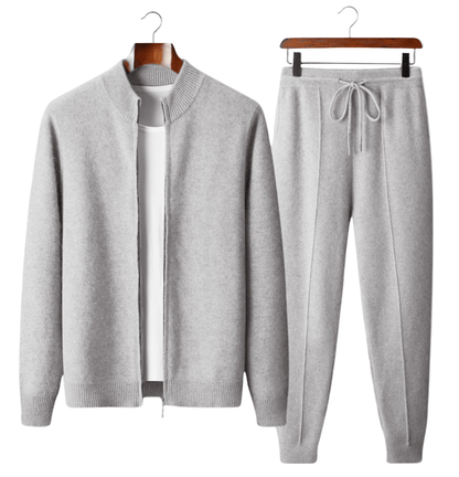 Gray sweater and jogger pants set on hangers against a white background