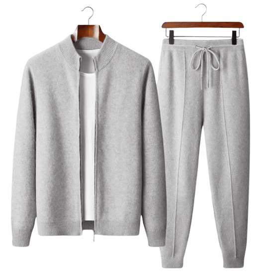Gray sweater and jogger pants set on hangers against a white background