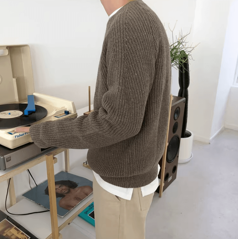 Men's brown relaxed-fit ribbed sweater featuring raglan sleeves and a 100% cotton knit construction.