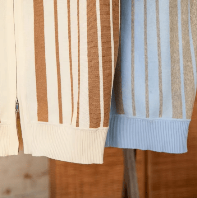 Close-up of the LORMIER metal zipper hardware and striped cuff on the breathable cotton knit cardigan.