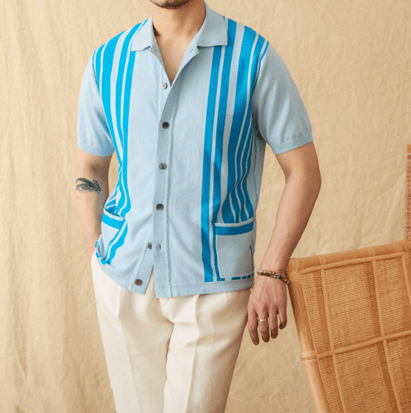 Men's light blue button-through knitted polo featuring a front pocket and white striped trim on the collar and cuffs.