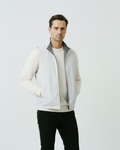 Men's minimalist reversible vest in gray-white, featuring a technical outer face and a soft-textured inner lining.