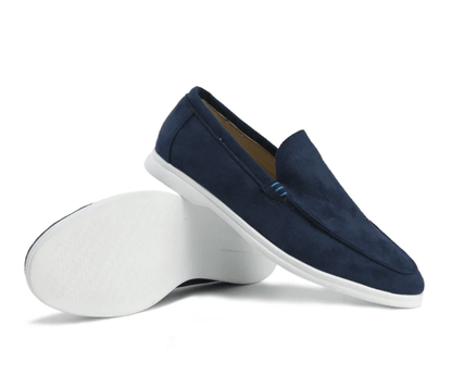 Navy loafers with white soles on a white background
