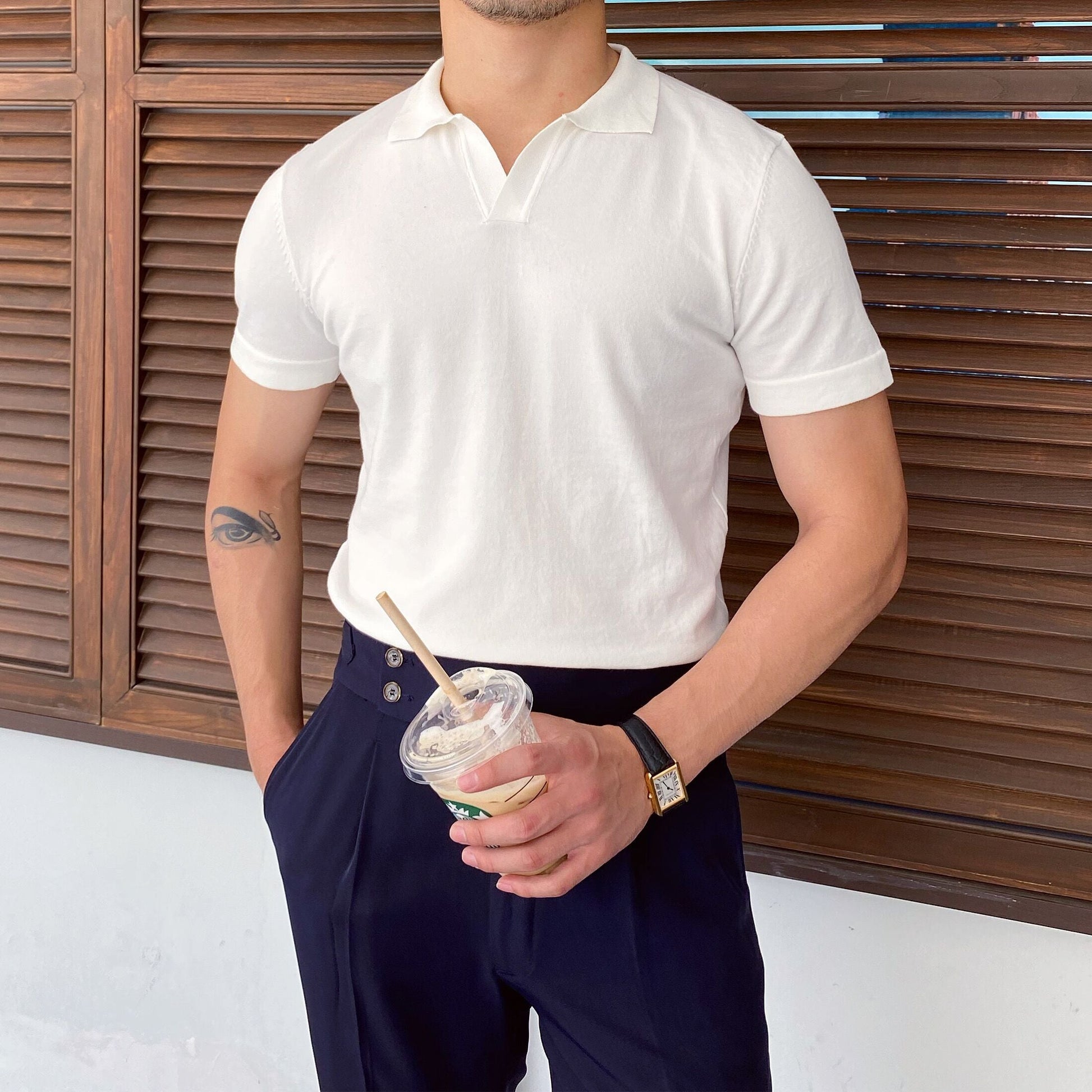 A clean, minimalist white cotton polo featuring a seamless V-neckline and tailored short sleeves.