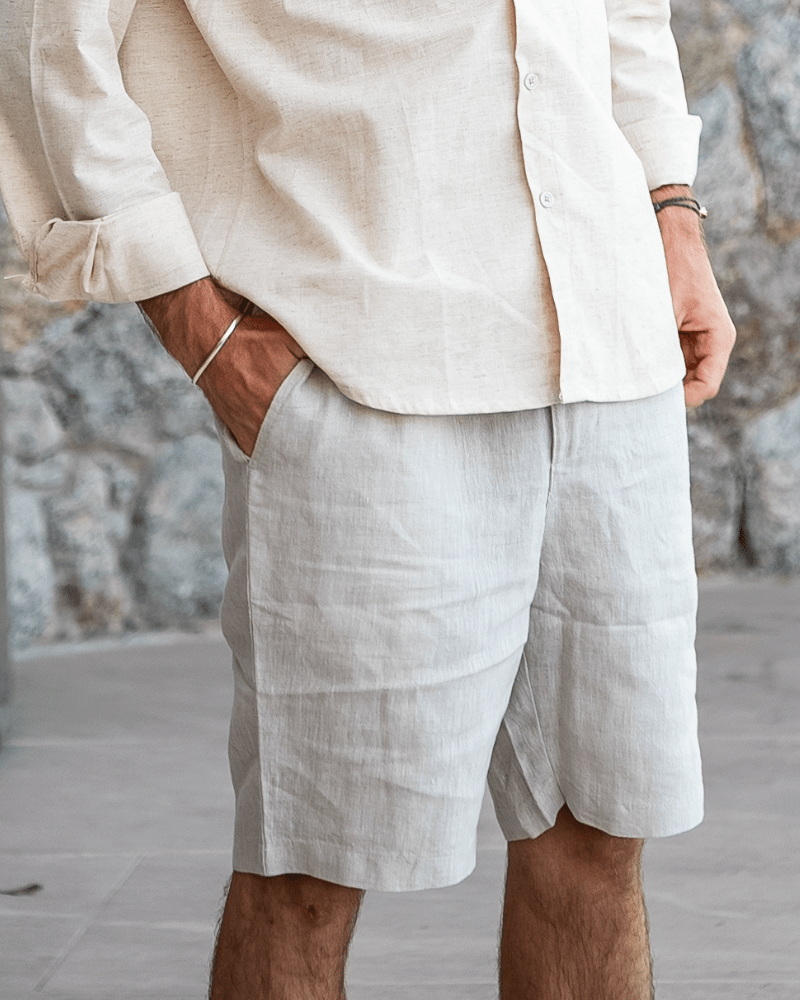 Men's beige linen shorts featuring an adjustable drawstring waistband and a refined tailored mid-thigh length.