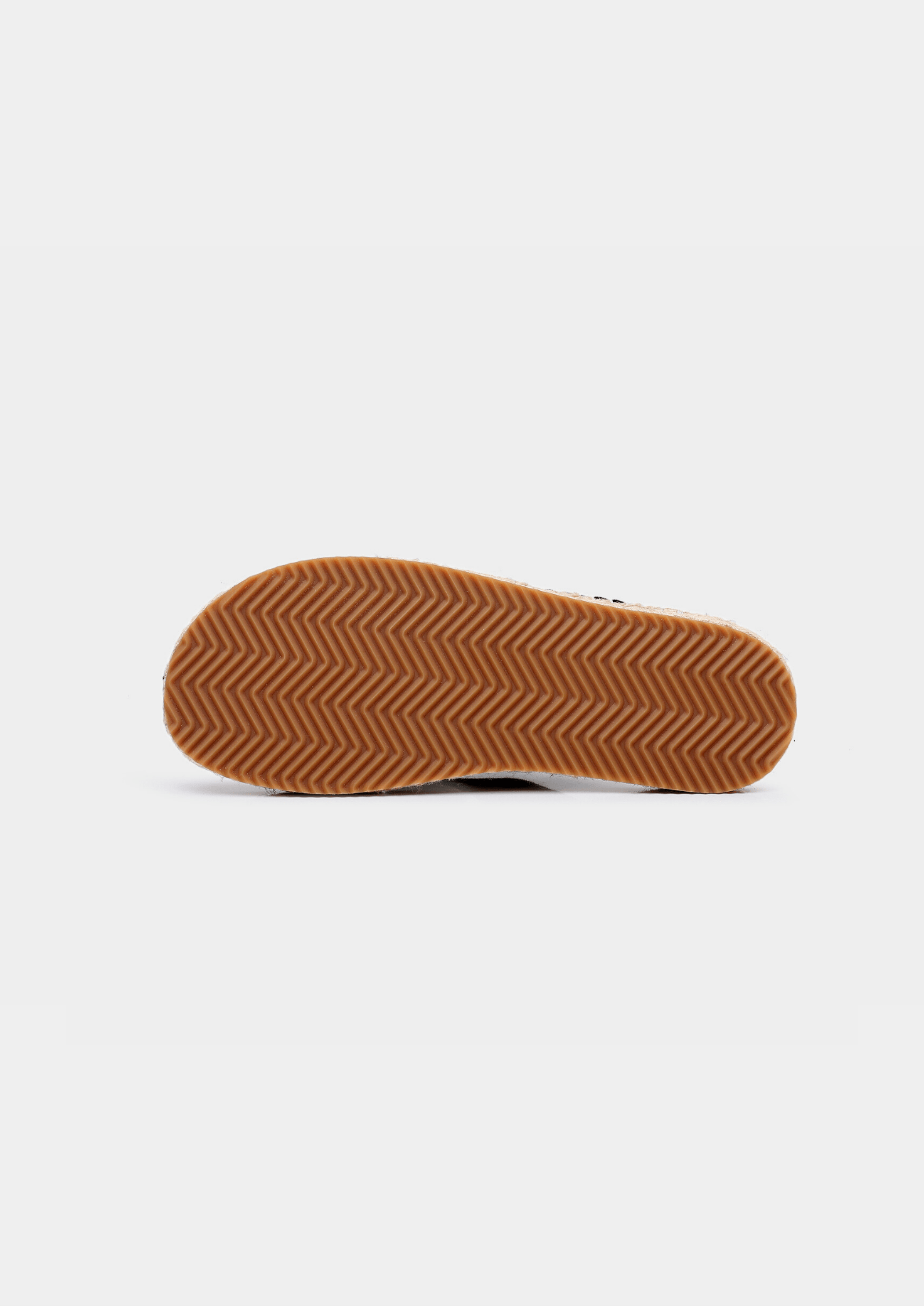 Close-up of a sandal sole with brown rubber tread on a white background
