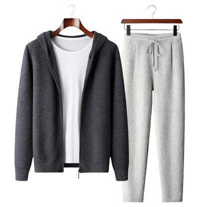 Gray hoodie and pants set on hangers against a white background