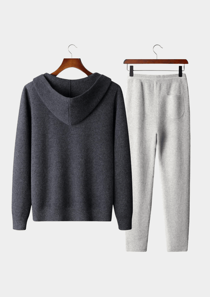 Gray hoodie and pants set on hangers against a white background