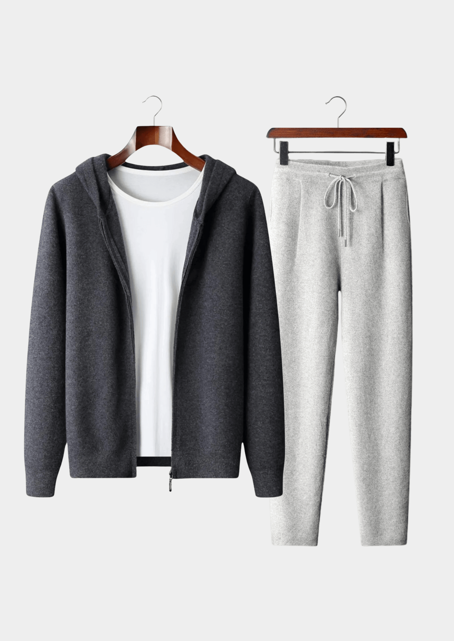 Gray hoodie and pants set on hangers against a white background
