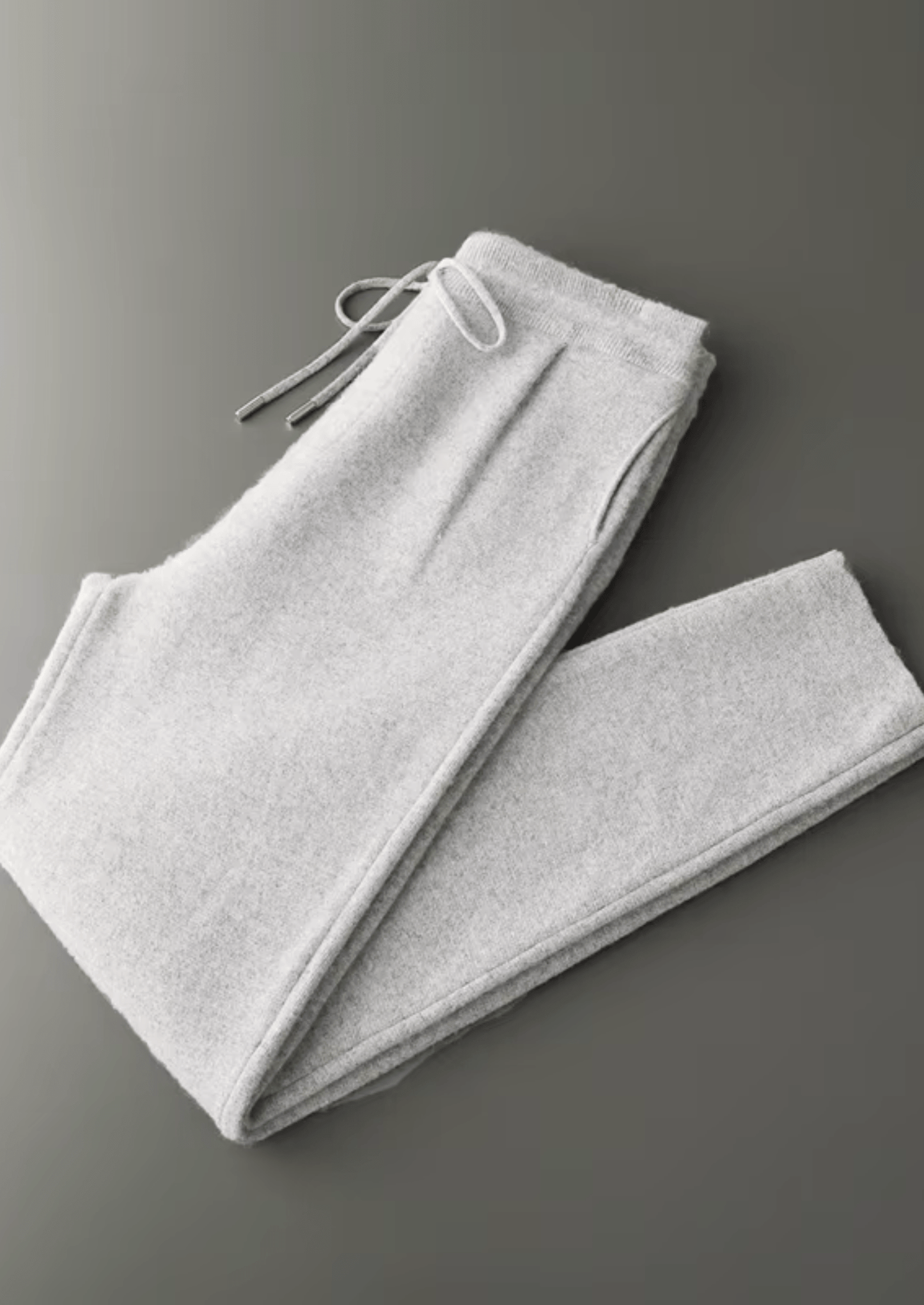 Folded gray sweatpants on a gray background