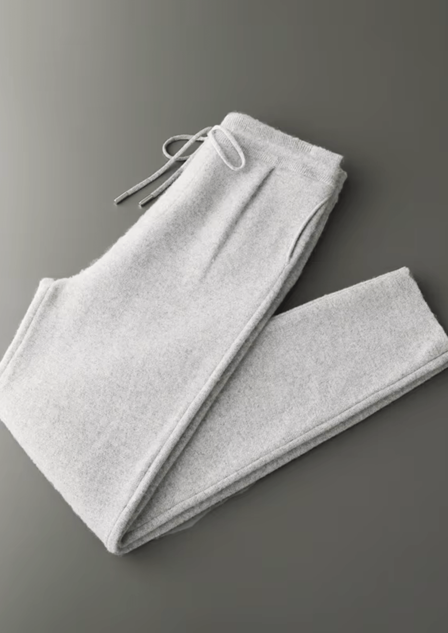 Folded gray sweatpants on a gray background