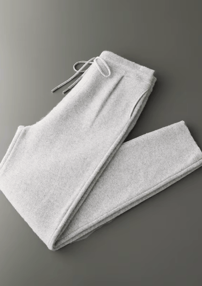 Folded gray sweatpants on a gray background