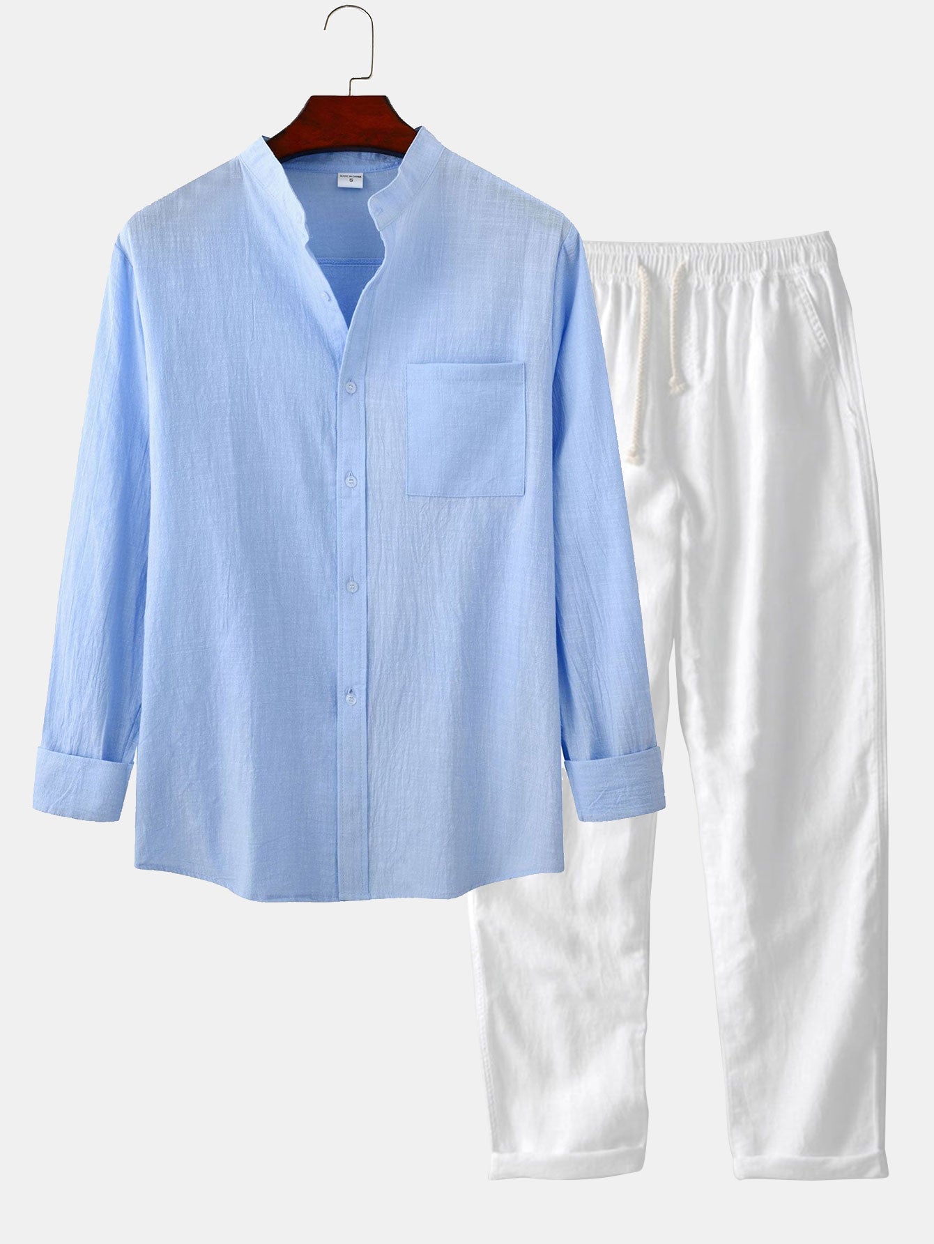 Light blue shirt and white pants on a hanger against a white background