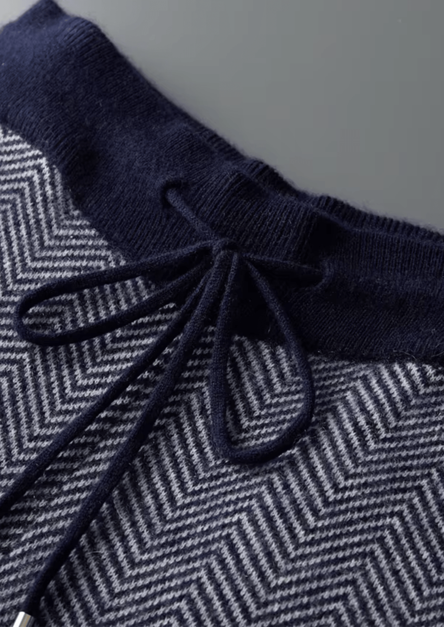 Navy blue and gray herringbone patterned fabric with a drawstring.