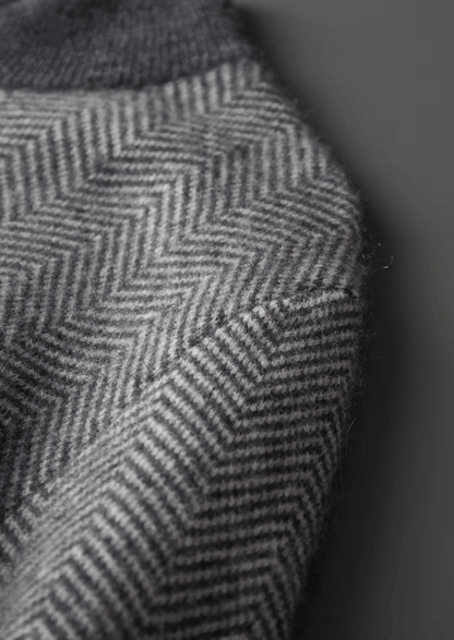 Close-up of a textured fabric with a herringbone pattern on a dark background