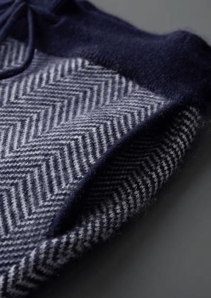Close-up of a dark blue fabric with a herringbone pattern on a gray background