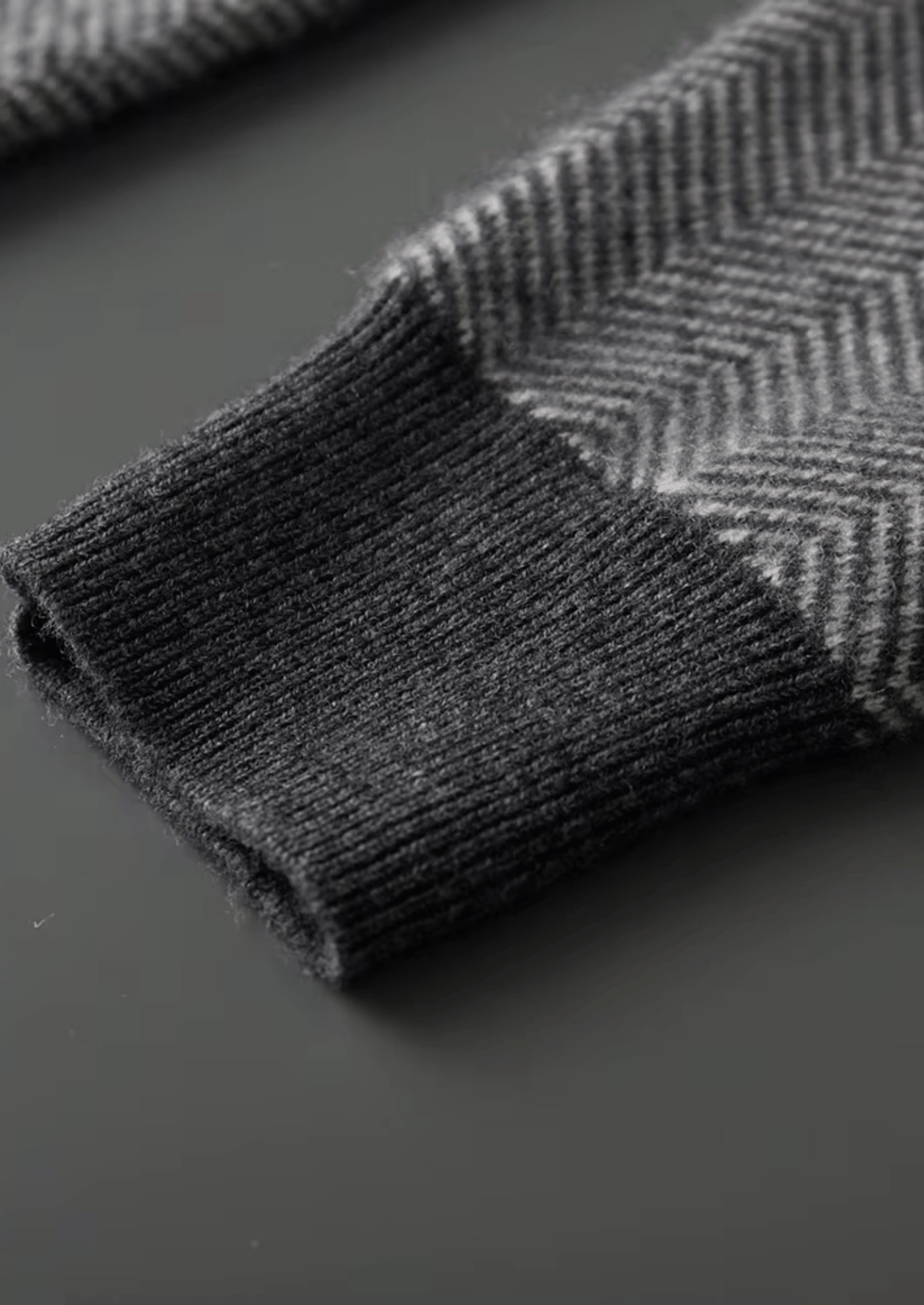 Dark gray herringbone patterned fabric on a dark surface