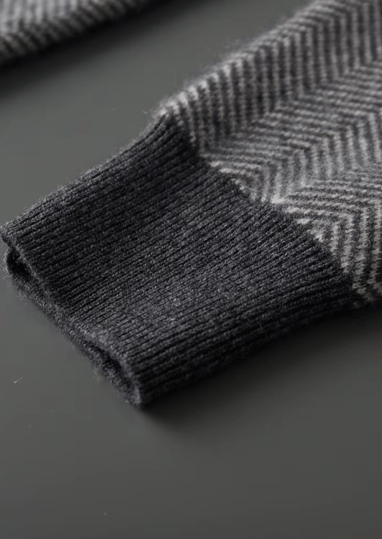 Dark gray herringbone patterned fabric on a dark surface
