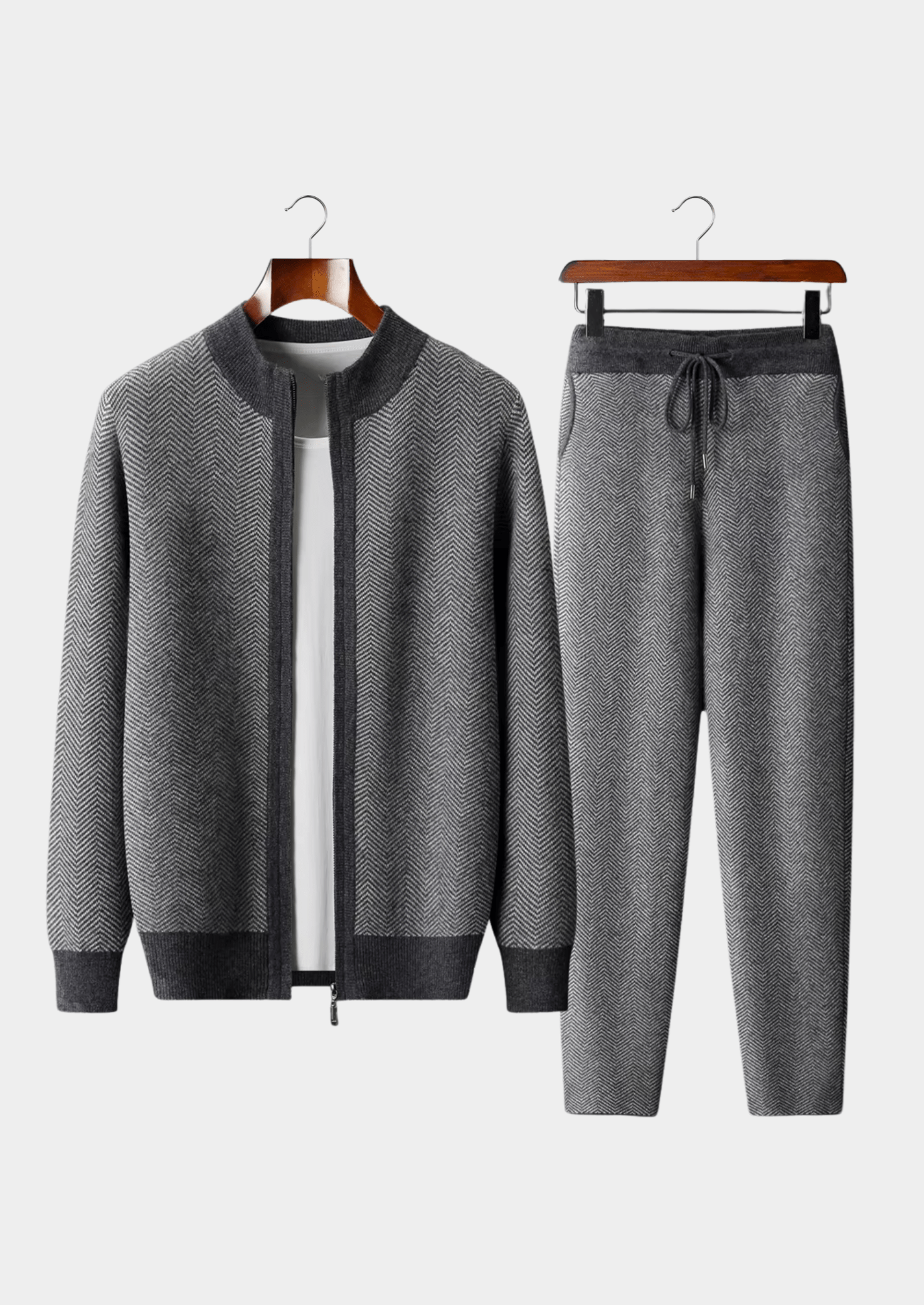 Gray tracksuit with jacket and pants on hangers against a white background