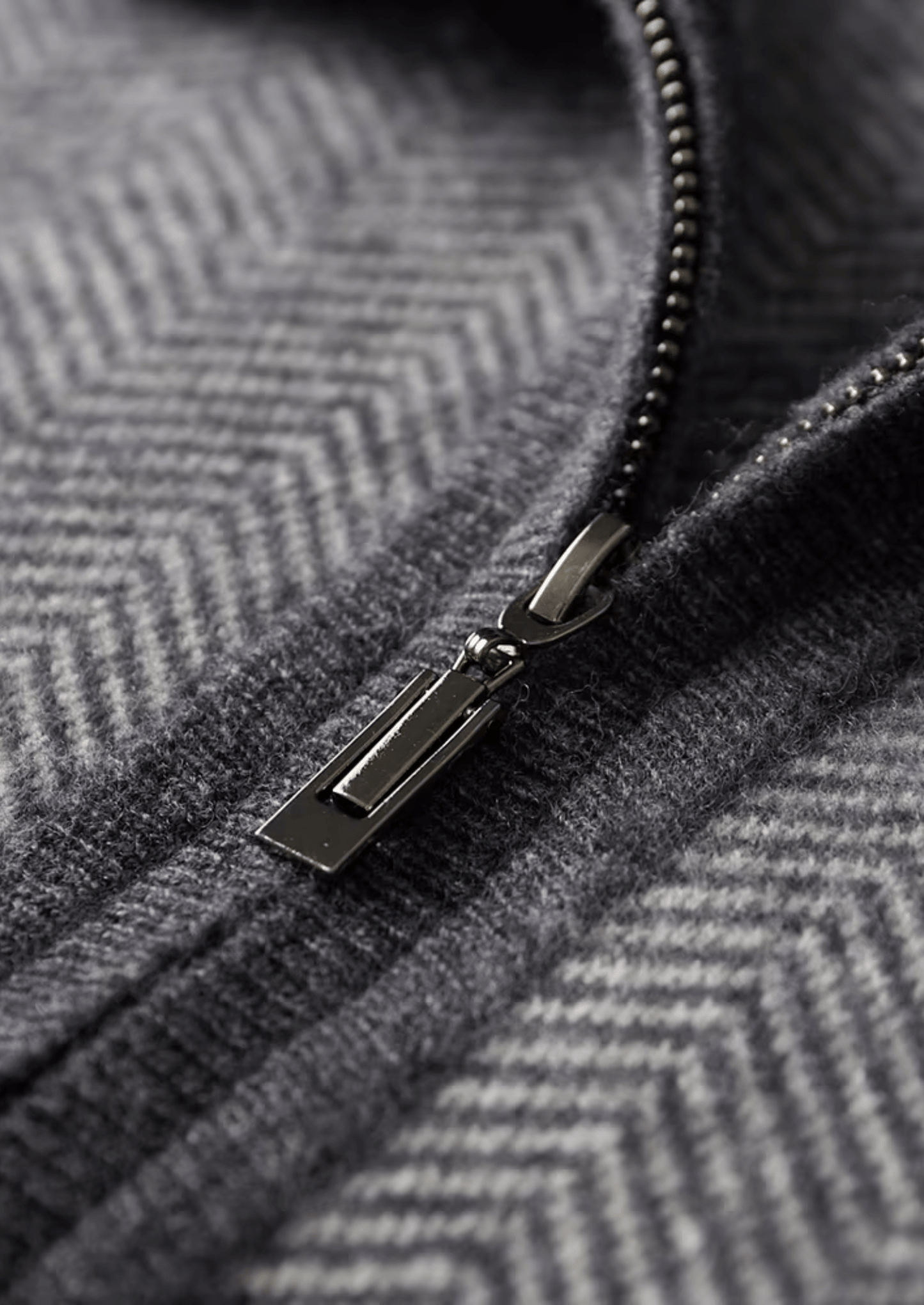 Close-up of a zipper on a textured gray fabric
