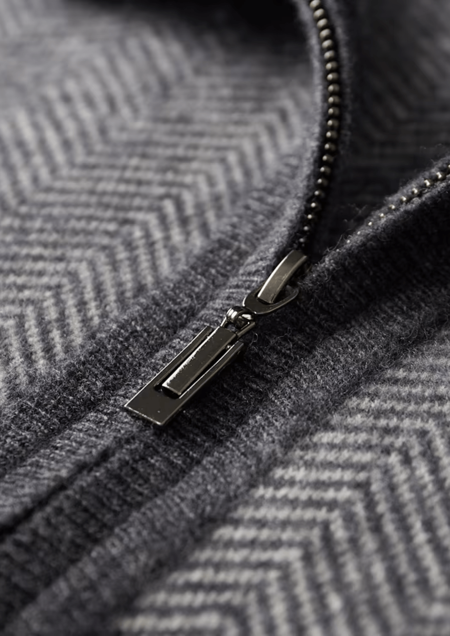 Close-up of a zipper on a textured gray fabric