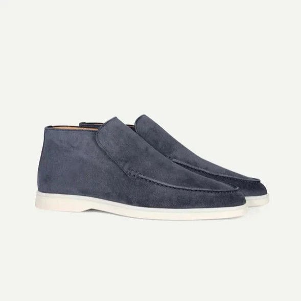 Pair of blue suede shoes on a light gray background