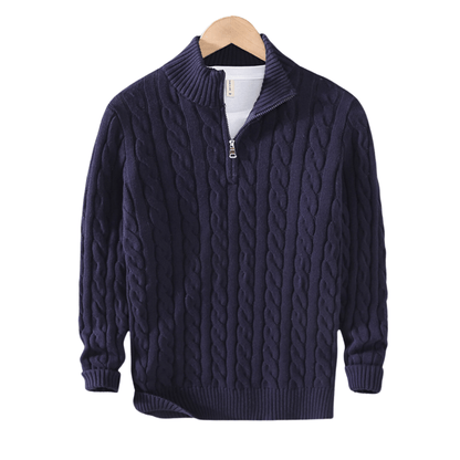 Navy blue cable knit sweater on a wooden hanger with a white background