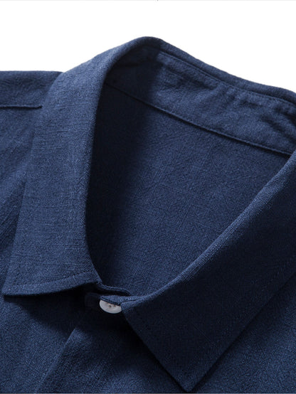 Close-up of a navy blue shirt collar with a button on a white background