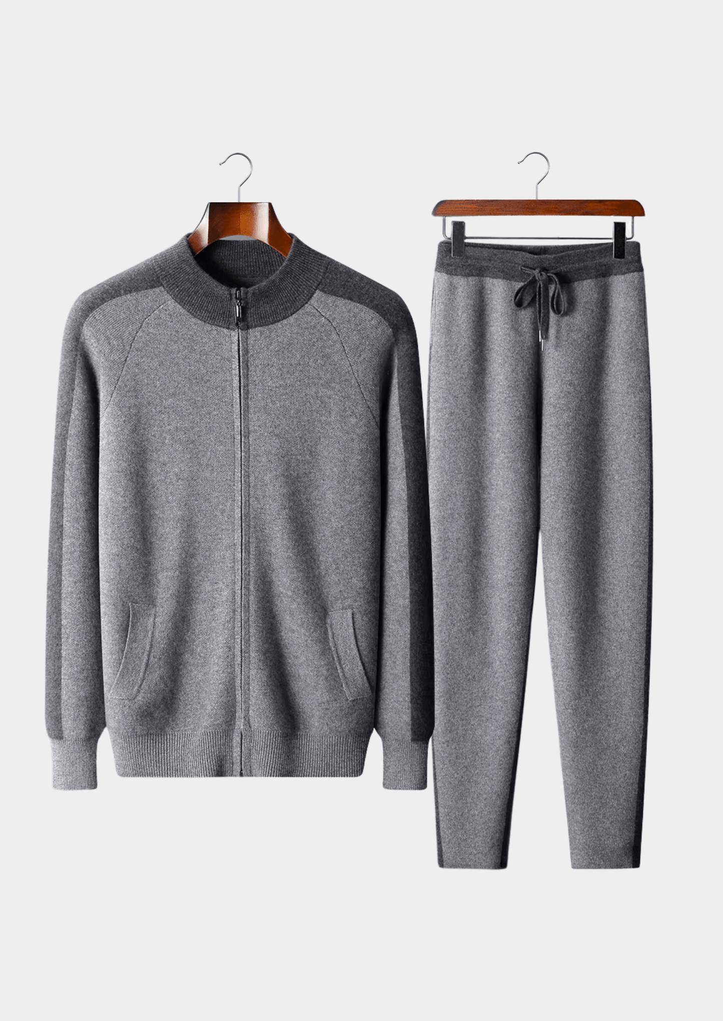 Gray tracksuit with a jacket and pants on hangers against a white background