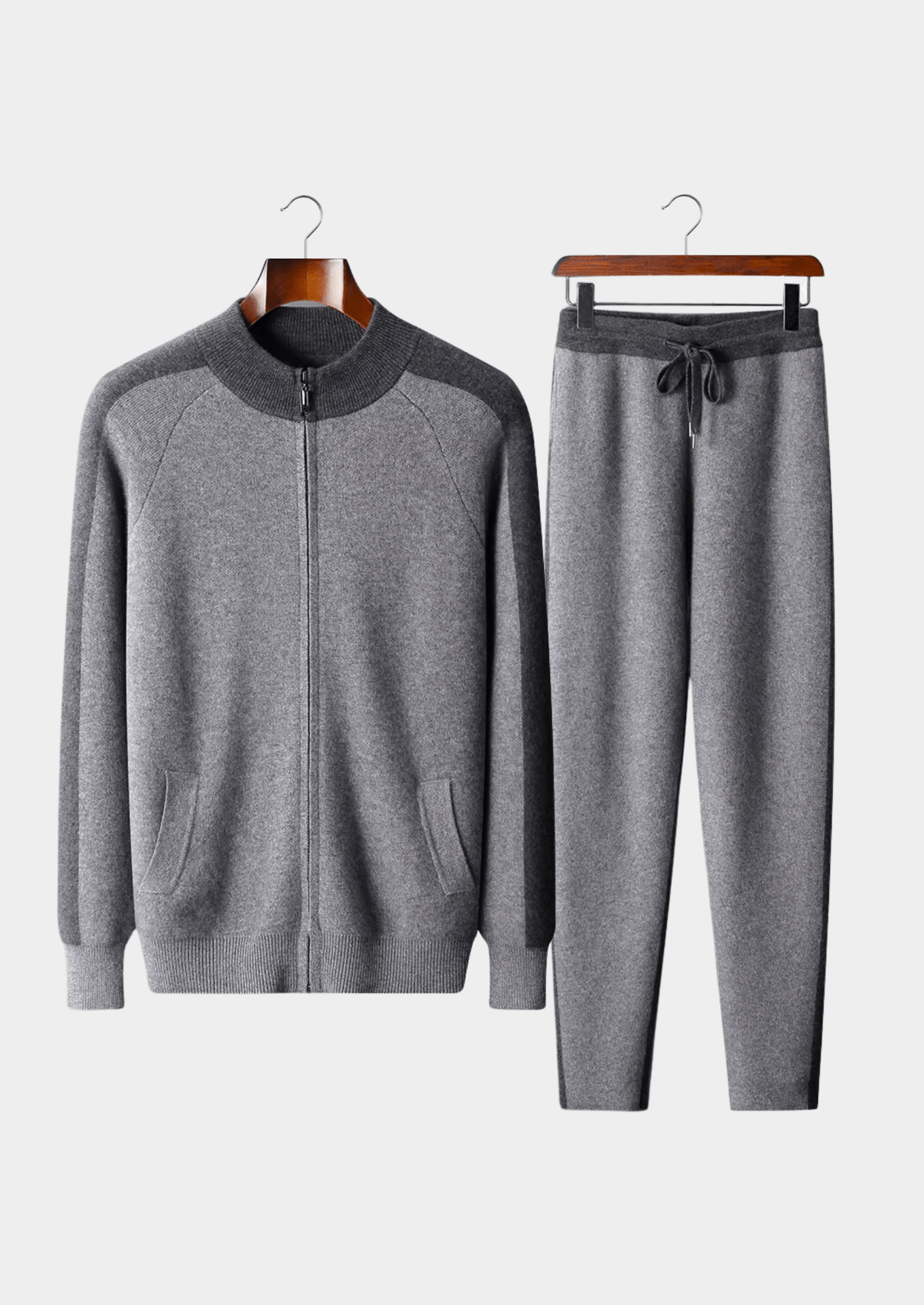 Gray tracksuit with a jacket and pants on hangers against a white background