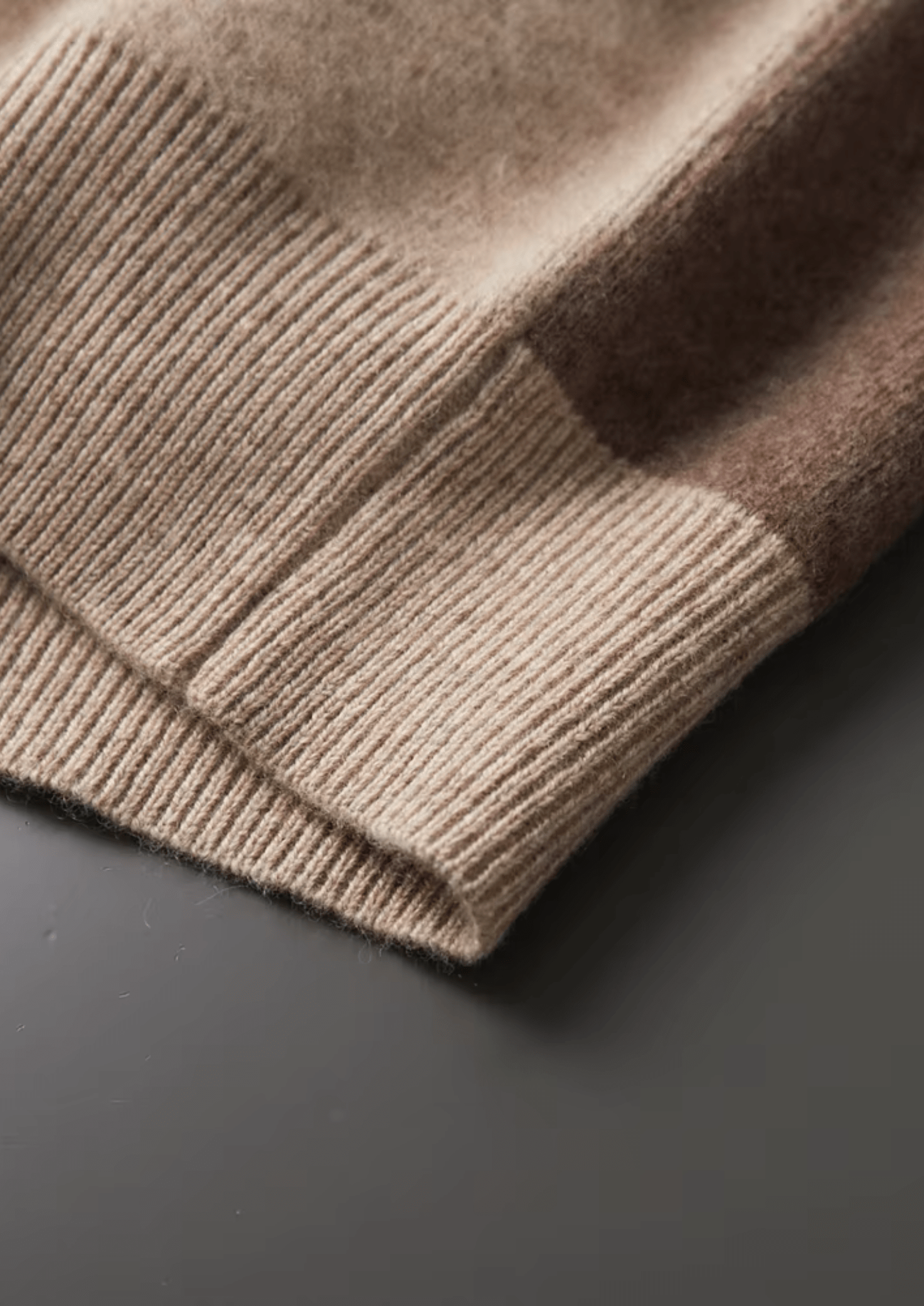 Close-up of a brown knitted sweater on a dark surface