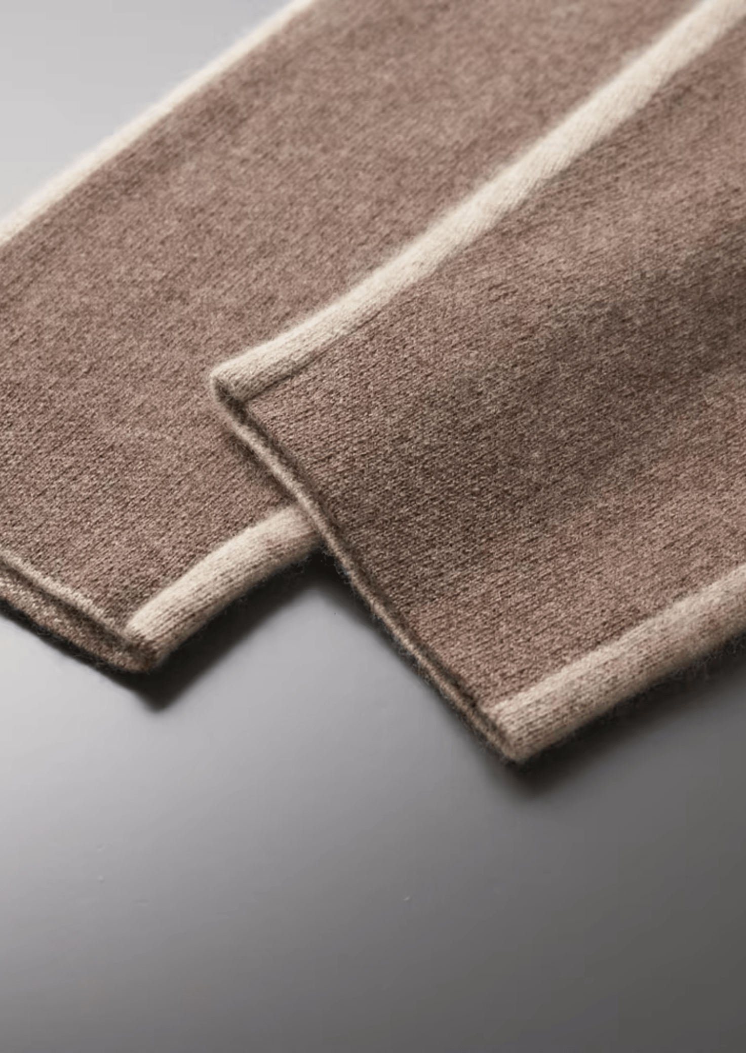 Two brown rectangular mats with white edges on a gray surface