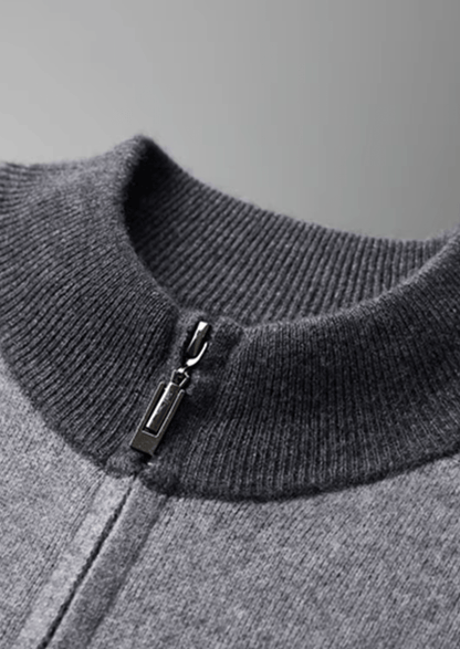 Close-up of a gray sweater with a zipper detail on a gray background