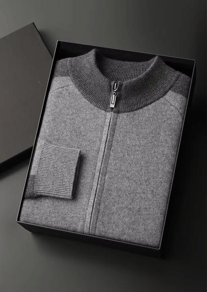 Gray zip-up sweater in a black box on a dark background