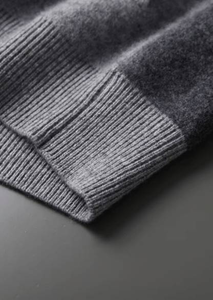 Close-up of a gray knitted sweater on a dark surface