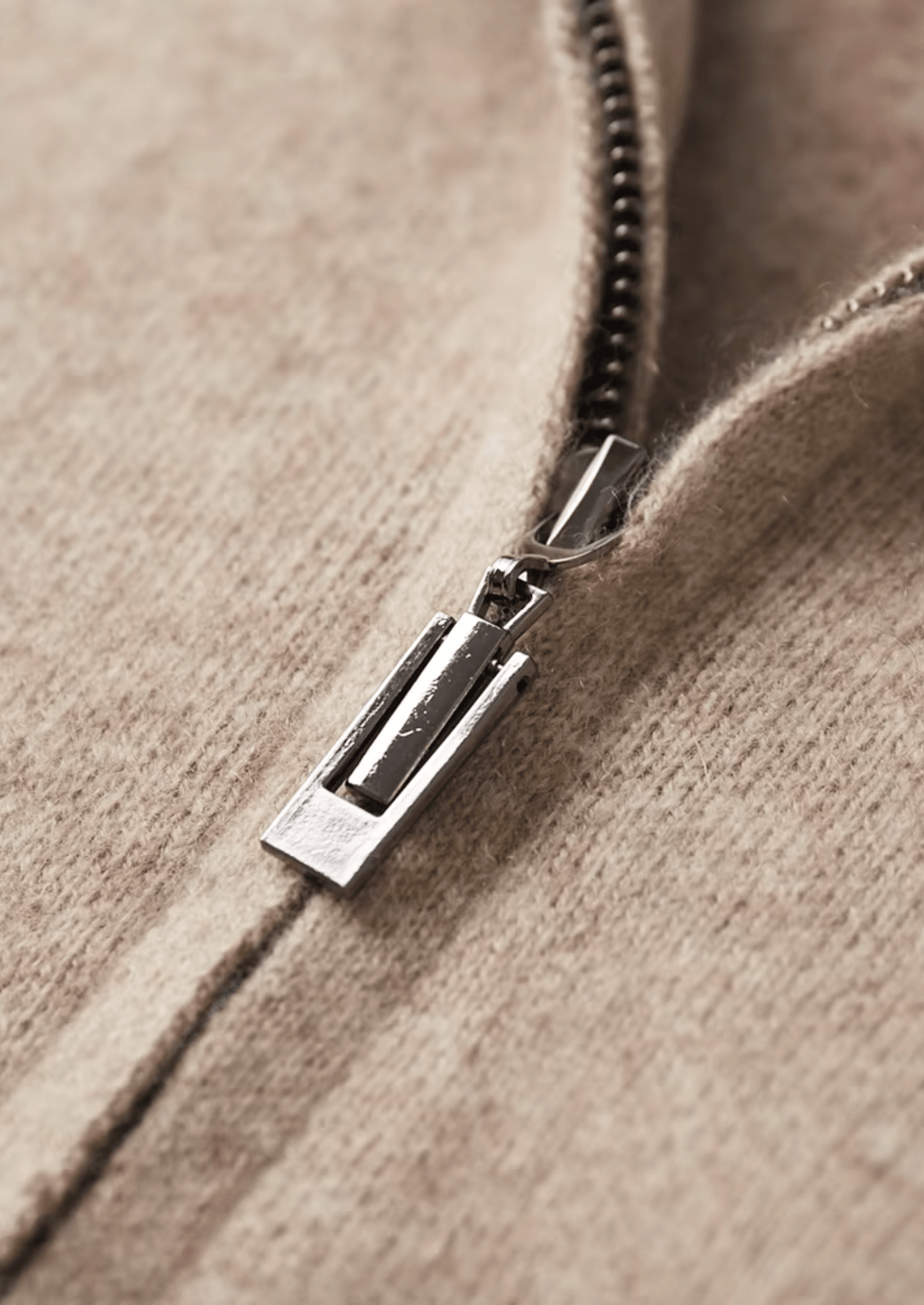 Close-up of a zipper on a textured beige fabric background