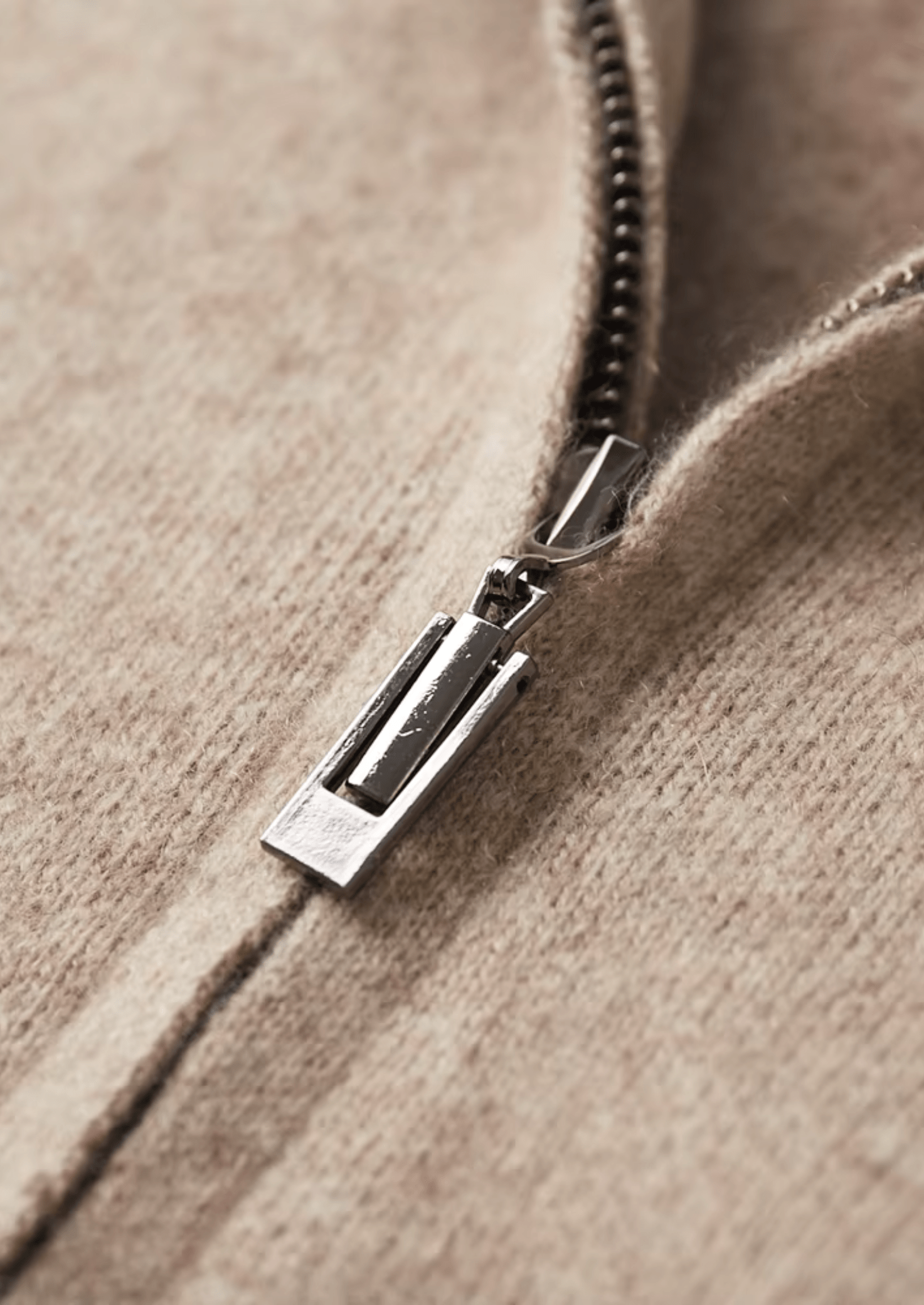 Close-up of a zipper on a textured beige fabric background