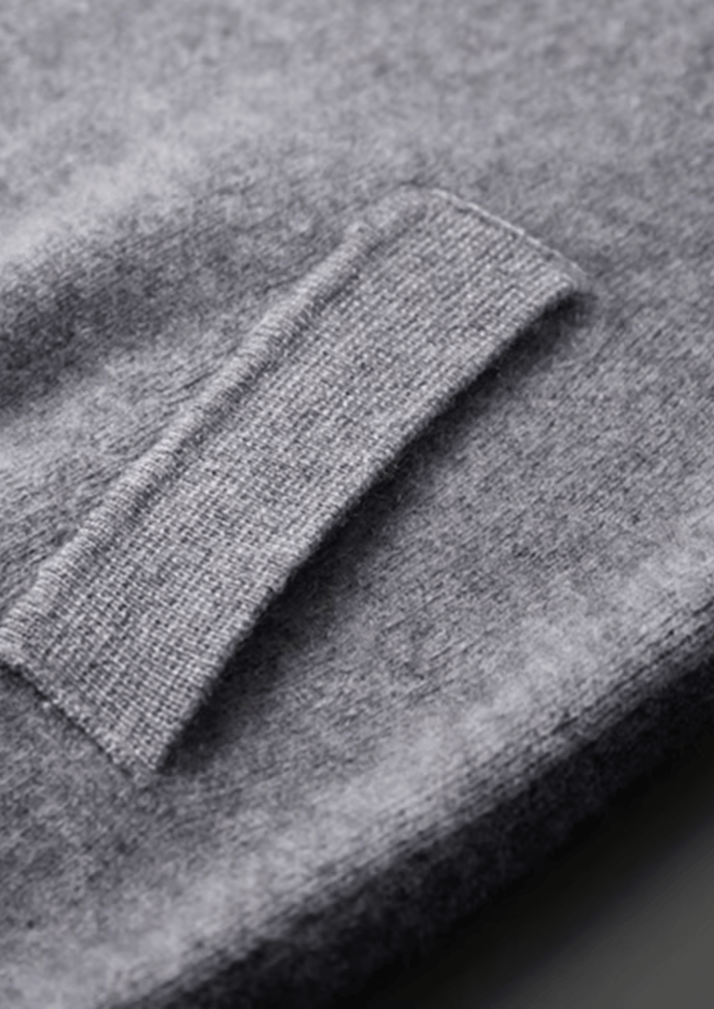Close-up of a gray sweater with a focus on the sleeve.