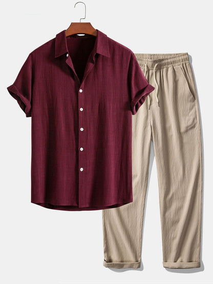 Maroon shirt and beige pants on a hanger against a white background