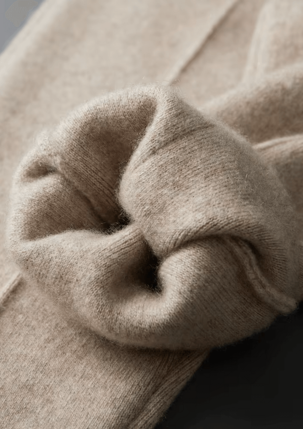 Close-up of a beige knitted sweater with a blurred background