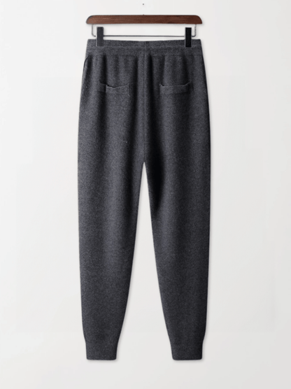 Gray sweatpants on a hanger against a white background